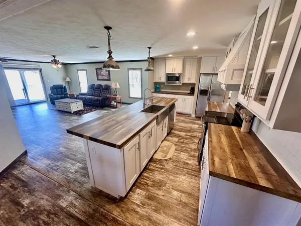 a large kitchen with stainless steel appliances granite countertop a lot of counter space and wooden floor