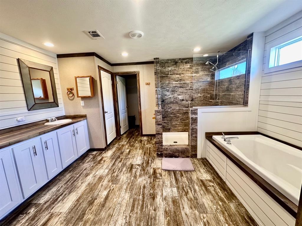 344 JP Cave Road Sherman, TX 75090 - Photo 17 of 21 a spacious bathroom with a granite countertop tub sink and wooden floor