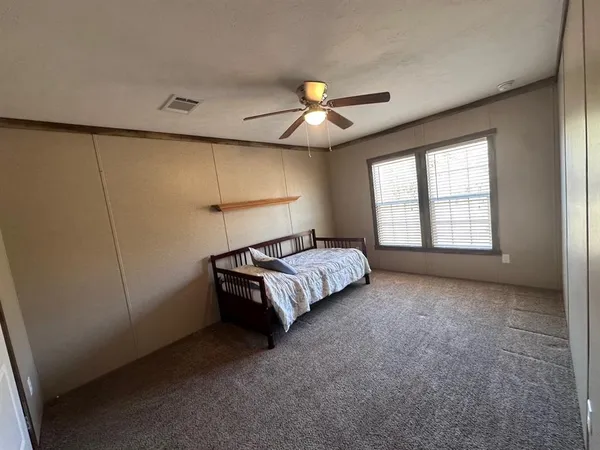 a spacious bedroom with a bed and a chandelier