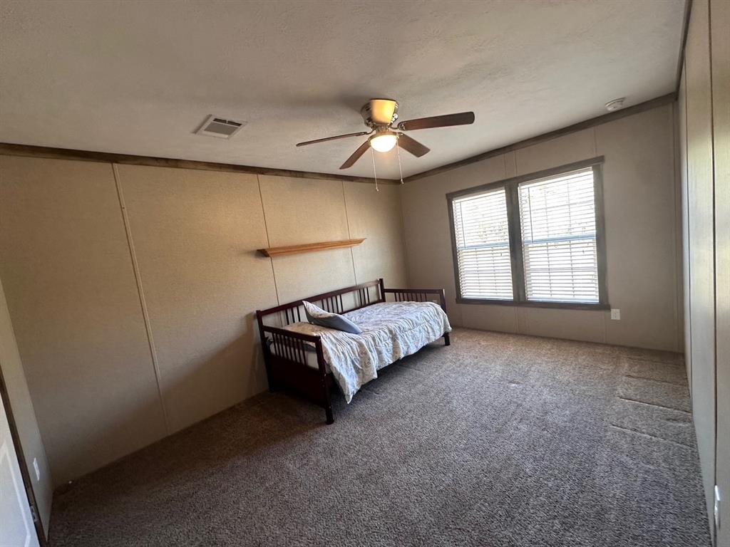 344 JP Cave Road Sherman, TX 75090 - Photo 19 of 21 a spacious bedroom with a bed and a chandelier