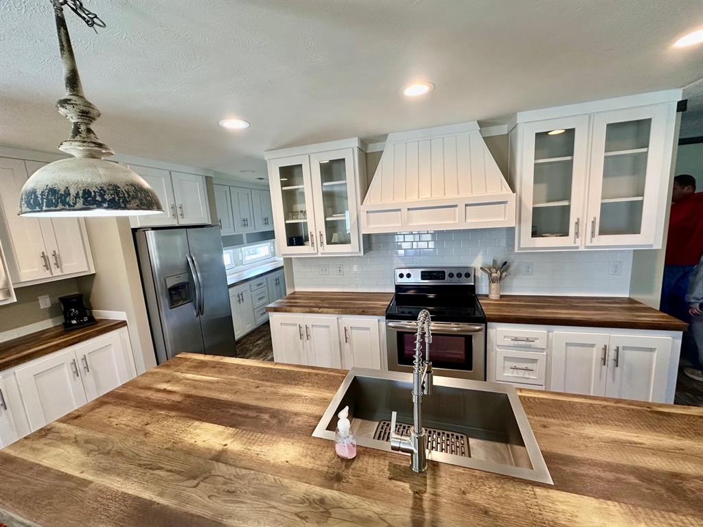344 JP Cave Road Sherman, TX 75090 - Photo 7 of 21 a kitchen with granite countertop a stove a sink dishwasher a refrigerator and a stove with wooden floor