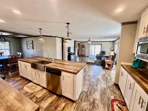 a large kitchen with stainless steel appliances granite countertop a lot of counter space and wooden floors