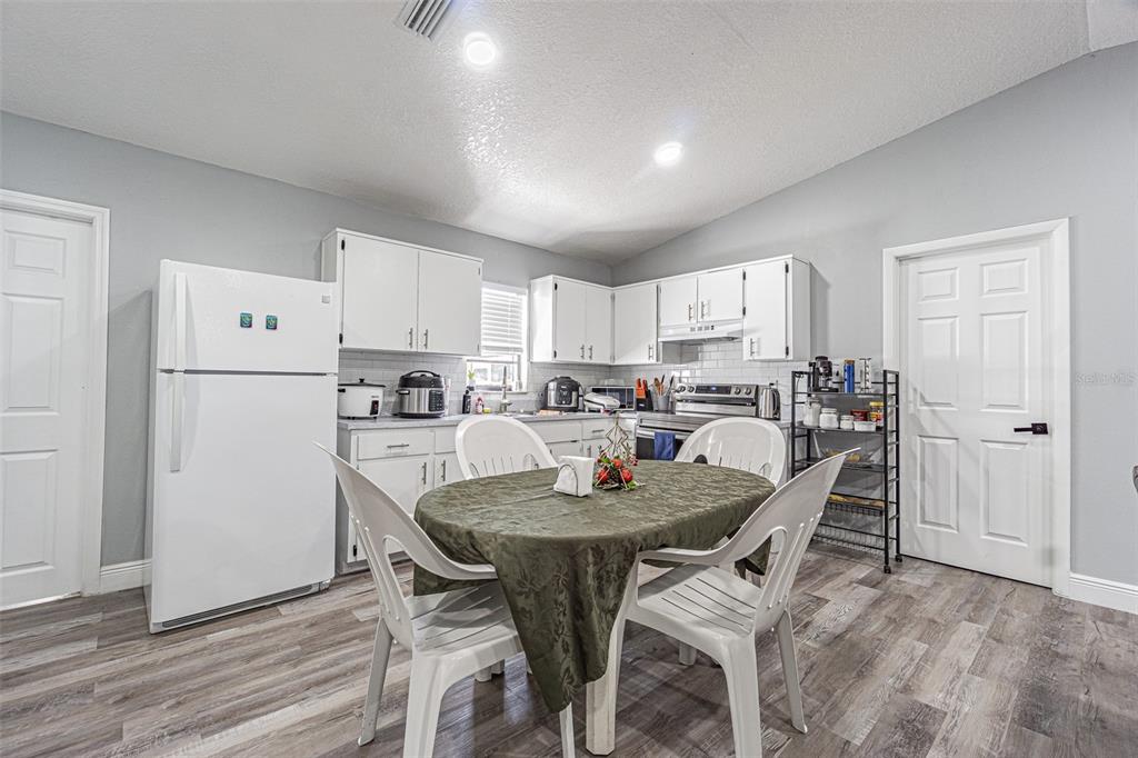 3482 Dow Lane Spring Hill, FL 34609 - Photo 12 of 30 a kitchen with refrigerator and chairs