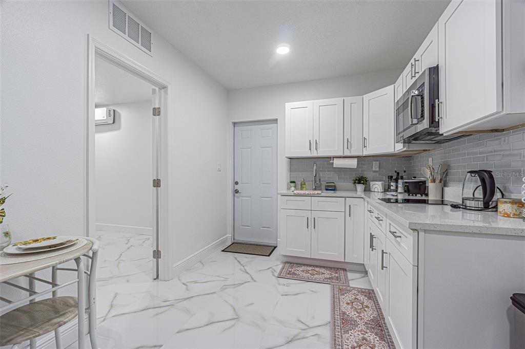 3482 Dow Lane Spring Hill, FL 34609 - Photo 24 of 30 a kitchen with granite countertop white cabinets and white appliances