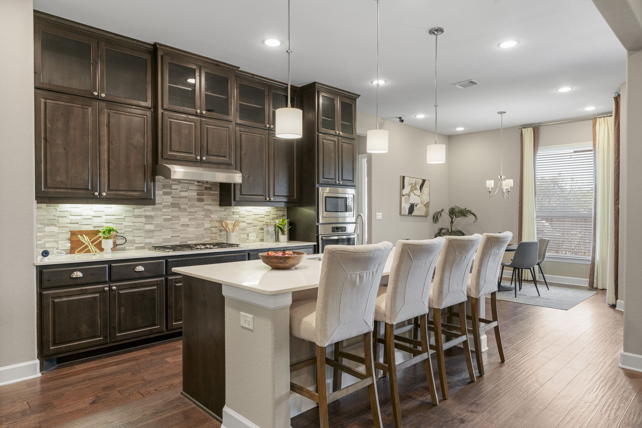110 Topaz Circle Dripping Springs, TX 78620 - Photo 12 of 40 The kitchen boasts a large entertainer's island lined with breakfast bar seating illuminated by pendant lighting above.
