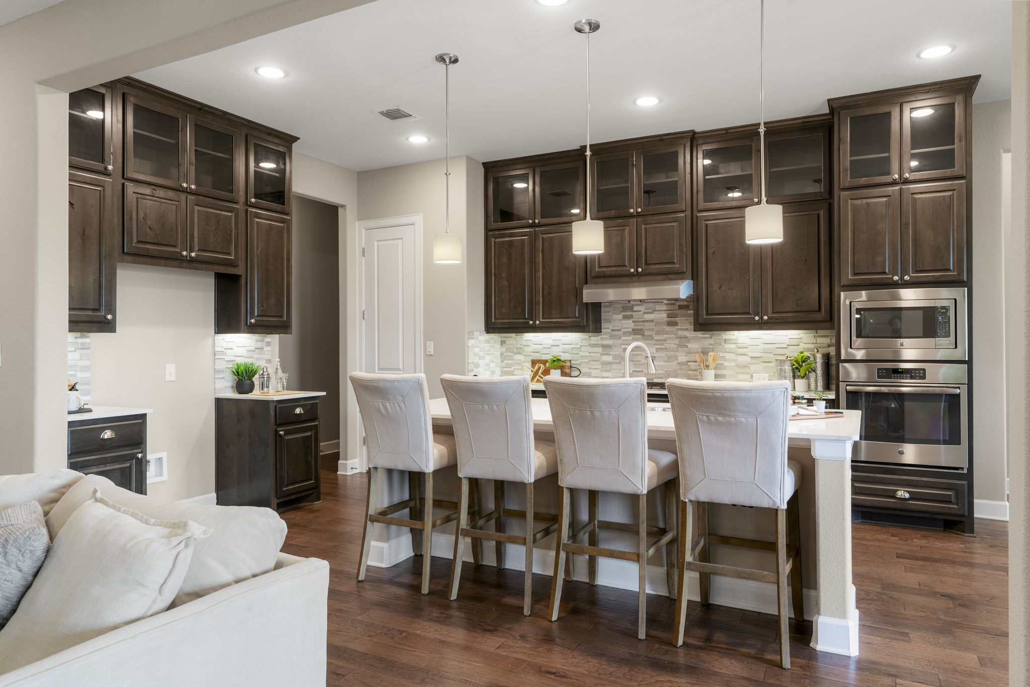 110 Topaz Circle Dripping Springs, TX 78620 - Photo 14 of 40 Featuring timeless cabinetry stacked to the ceiling with glass showcase cabinet front on the upper level and under-lit cabinets that illuminate the granite countertops below.