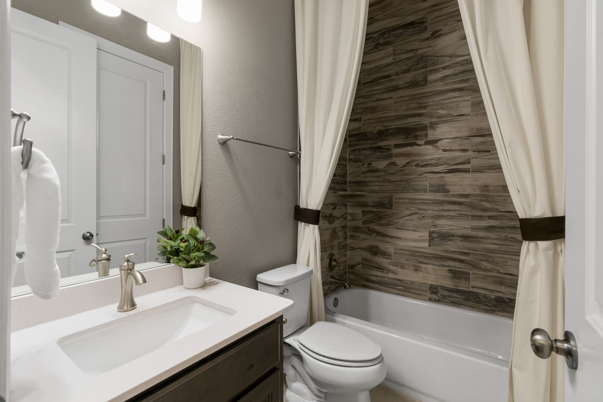 110 Topaz Circle Dripping Springs, TX 78620 - Photo 27 of 40 The ensuite bathroom for the secluded secondary bedroom comes with a shower/tub combo with designer tile backsplash.
