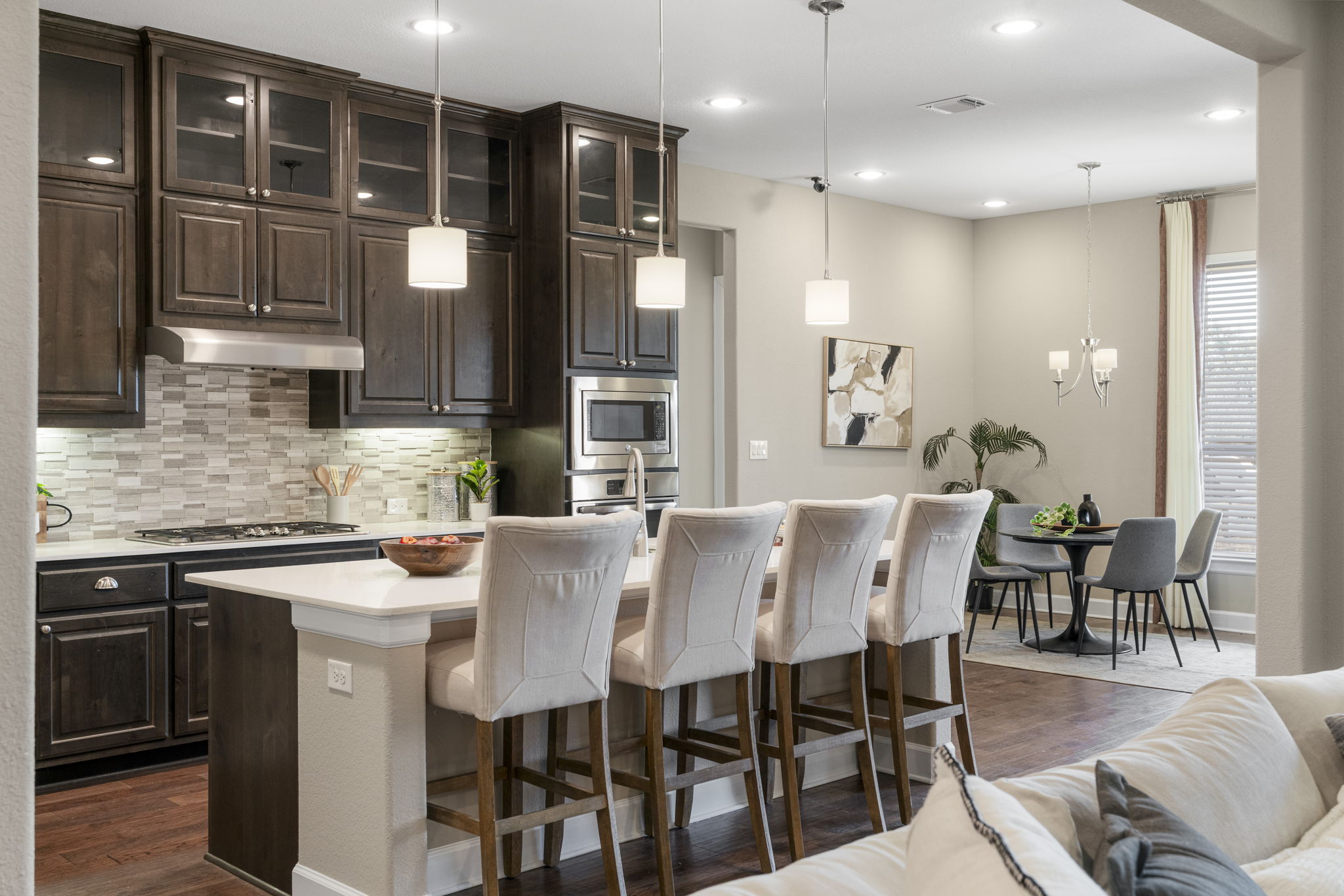 110 Topaz Circle Dripping Springs, TX 78620 - Photo 3 of 40 The gourmet island kitchen serves as the heart of the home, overlooking the main living area for seamless connectivity, with inviting bar seating and a sunny breakfast area.