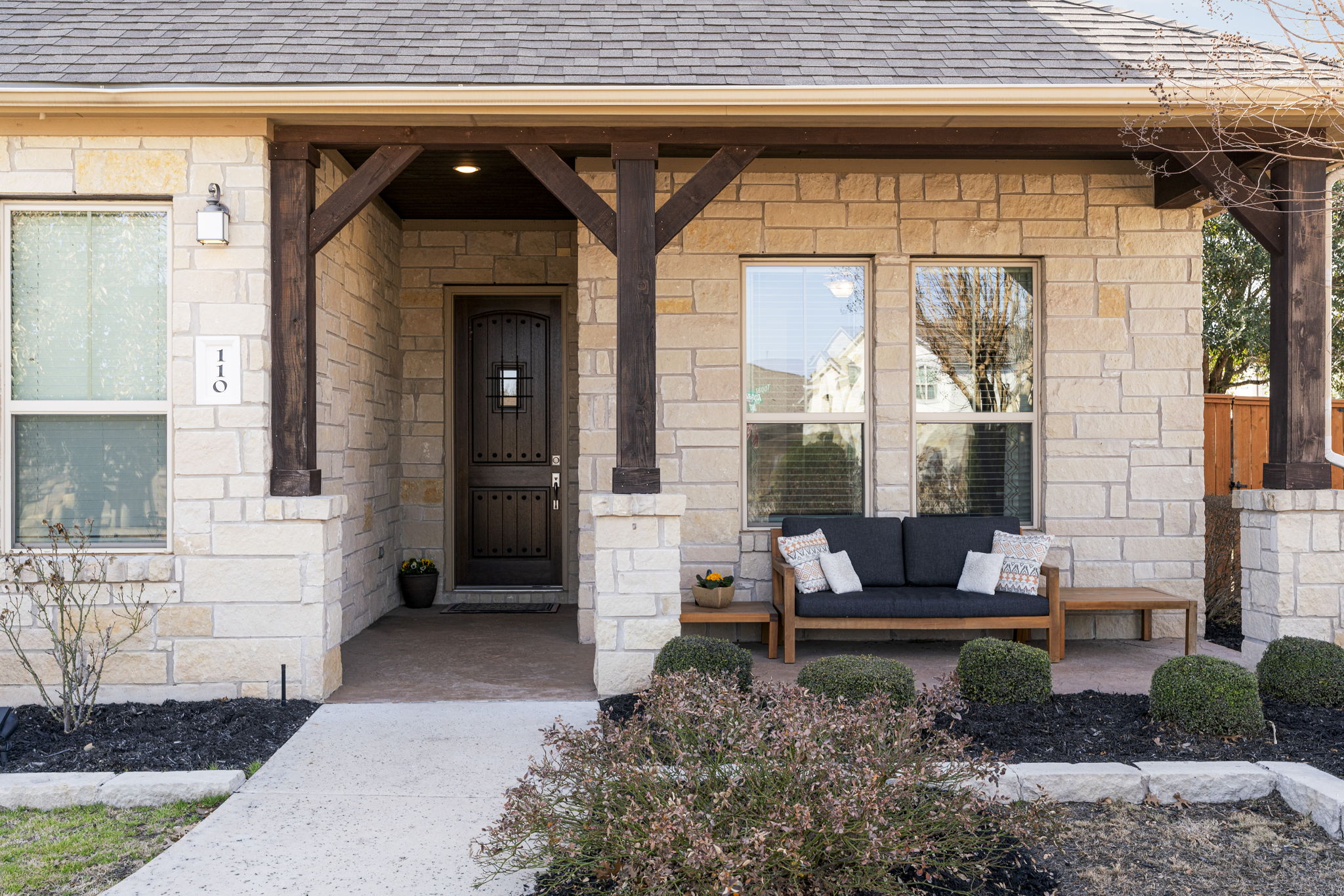 110 Topaz Circle Dripping Springs, TX 78620 - Photo 9 of 40 Lush landscaping wraps around all sides of the home providing for welcoming curb appeal along with a charming covered front porch.