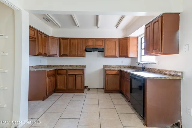a kitchen with a stove sink and cabinets