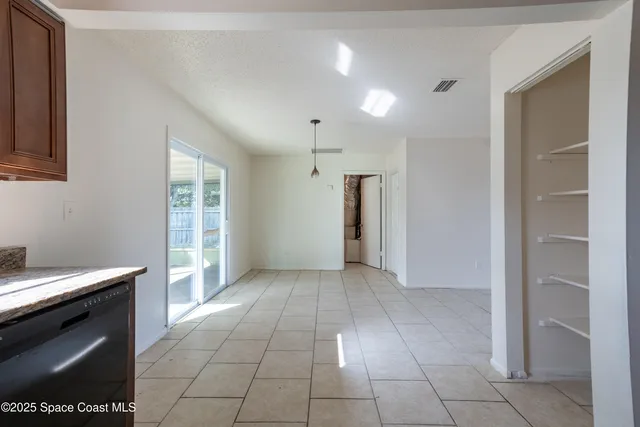 a view of a kitchen with an empty space and a window