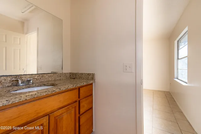 a bathroom with a granite countertop sink and a mirror