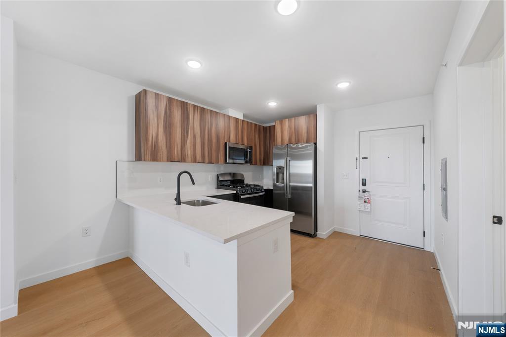 768 Bergen Street, Unit 5D Newark, NJ 07108 - Photo 2 of 14 a kitchen with kitchen island a sink stainless steel appliances and cabinets