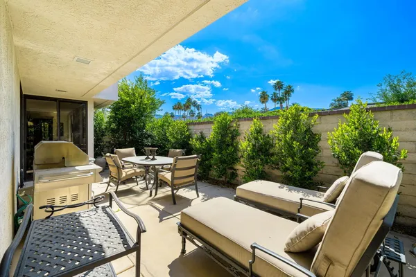 a view of a patio with couches table and chairs and potted plants