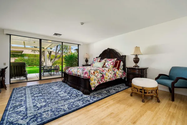 a bedroom with a bed chair and a large window