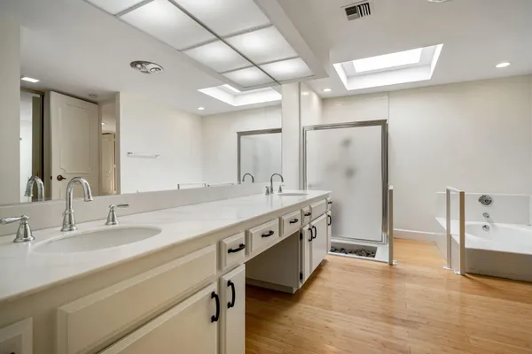 a spacious bathroom with a granite countertop sink a toilet a mirror and shower