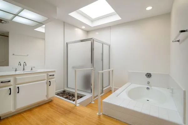 a bathroom with a tub sink and mirror