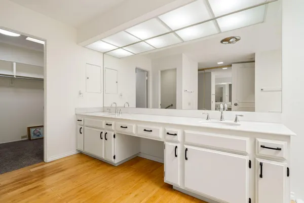 a spacious bathroom with double sink and a large mirror