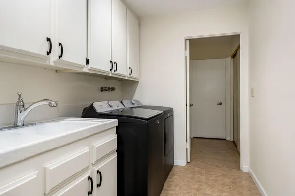 a utility room with sink dryer and washer