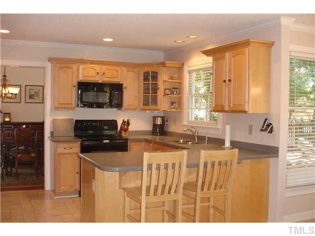 9105 Doublebit Drive Raleigh, NC 27615 - Photo 1 of 20 Wonderful kitchen with maple cabinets trimmed with dentil molding, solid surface tops, undermount sink, stove replaced in 2008, microwave in 2009. Bar stool seating makes entertaining easy!
