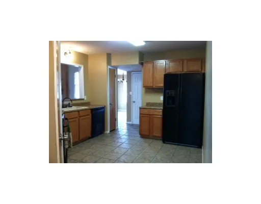 a living room with kitchen island and a refrigerator