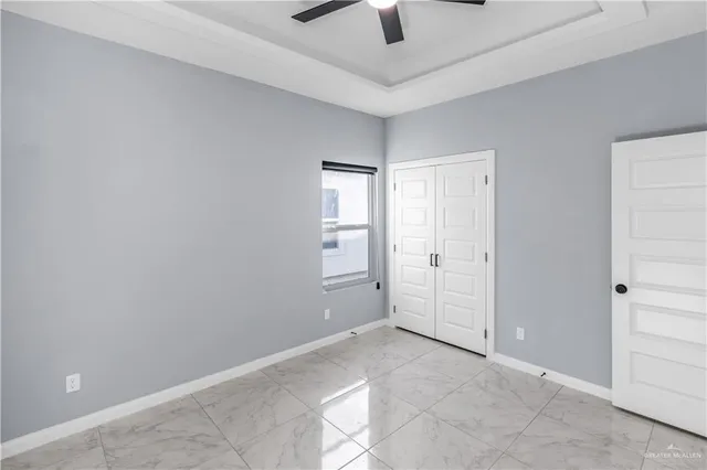 an empty room with closet and windows