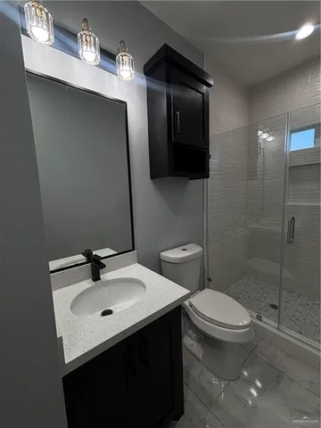 a bathroom with a shower a toilet and a sink