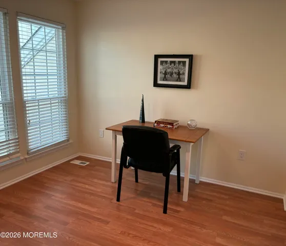 a view of a workspace with furniture and a window