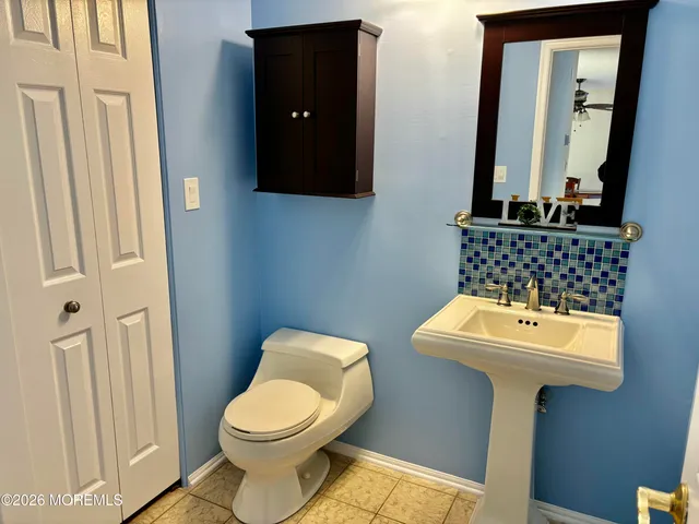 a bathroom with a toilet sink and mirror