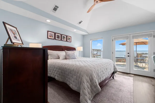 a spacious bedroom with a bed a dresser and a window