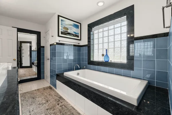 a bathroom with a large tub a sink and a shower