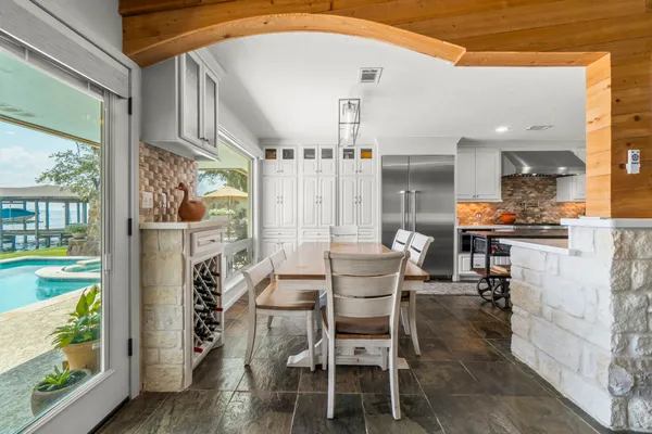 a dining room with furniture and large windows
