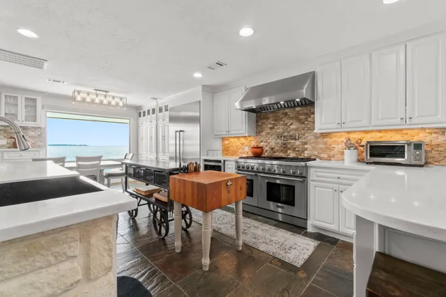 a kitchen with granite countertop a stove a sink and a refrigerator