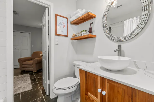a bathroom with a toilet a sink and a mirror