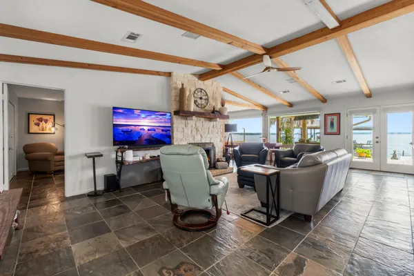 a living room with couches a flat screen tv and chairs