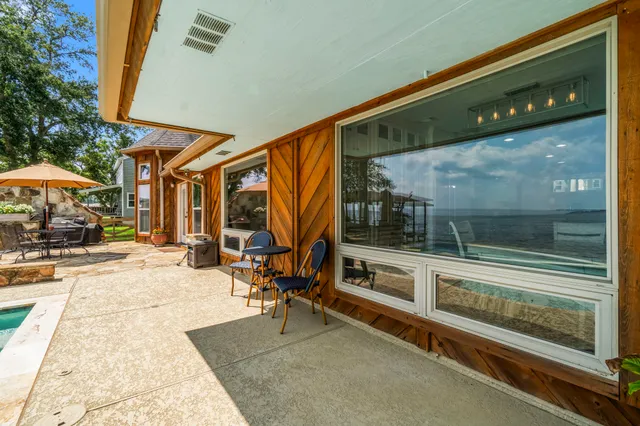 a view of a patio with a table and chairs under an umbrella