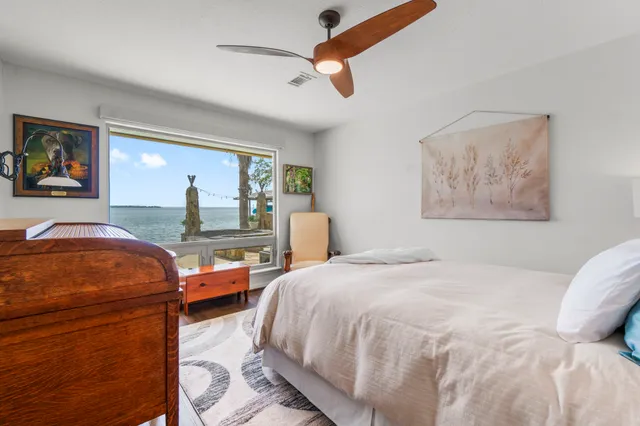 a bedroom with a bed a ceiling fan and a dresser