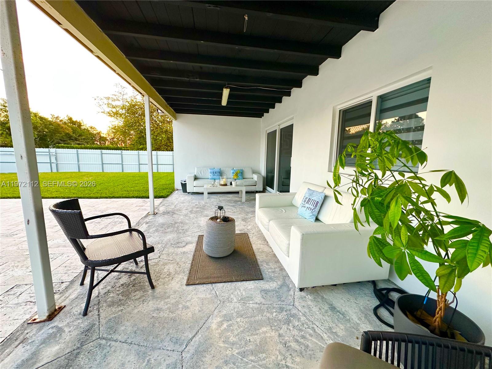 9230 Southwest 68th Street Miami, FL 33173 - Photo 24 of 29 a living room with patio furniture and a garden