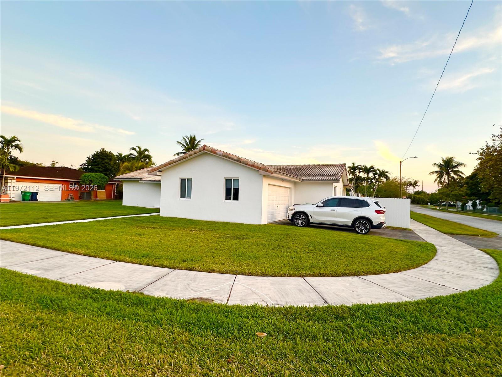 9230 Southwest 68th Street Miami, FL 33173 - Photo 26 of 29 a front view of a house with a yard and garage