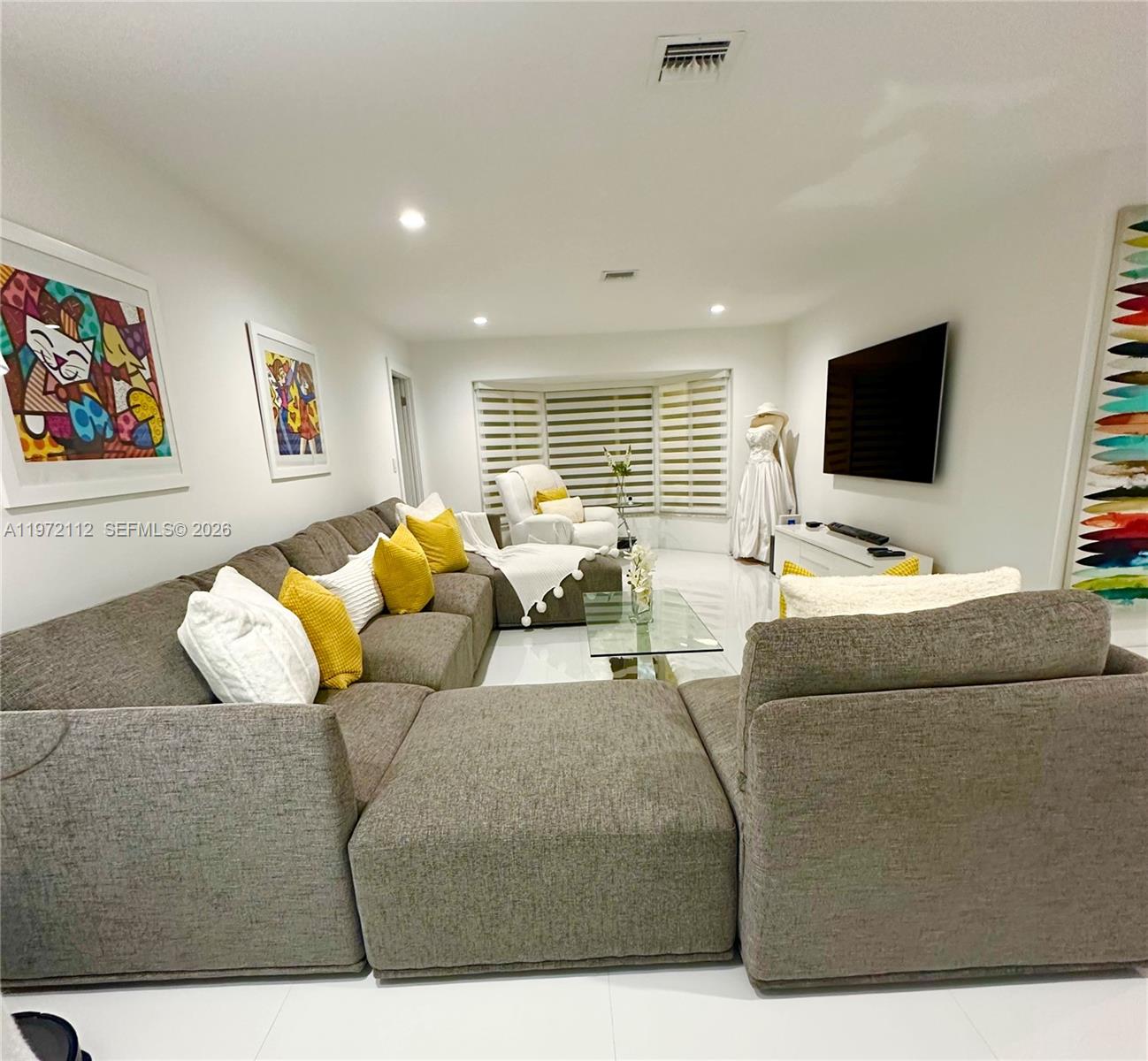 9230 Southwest 68th Street Miami, FL 33173 - Photo 4 of 29 a living room with furniture and a flat screen tv