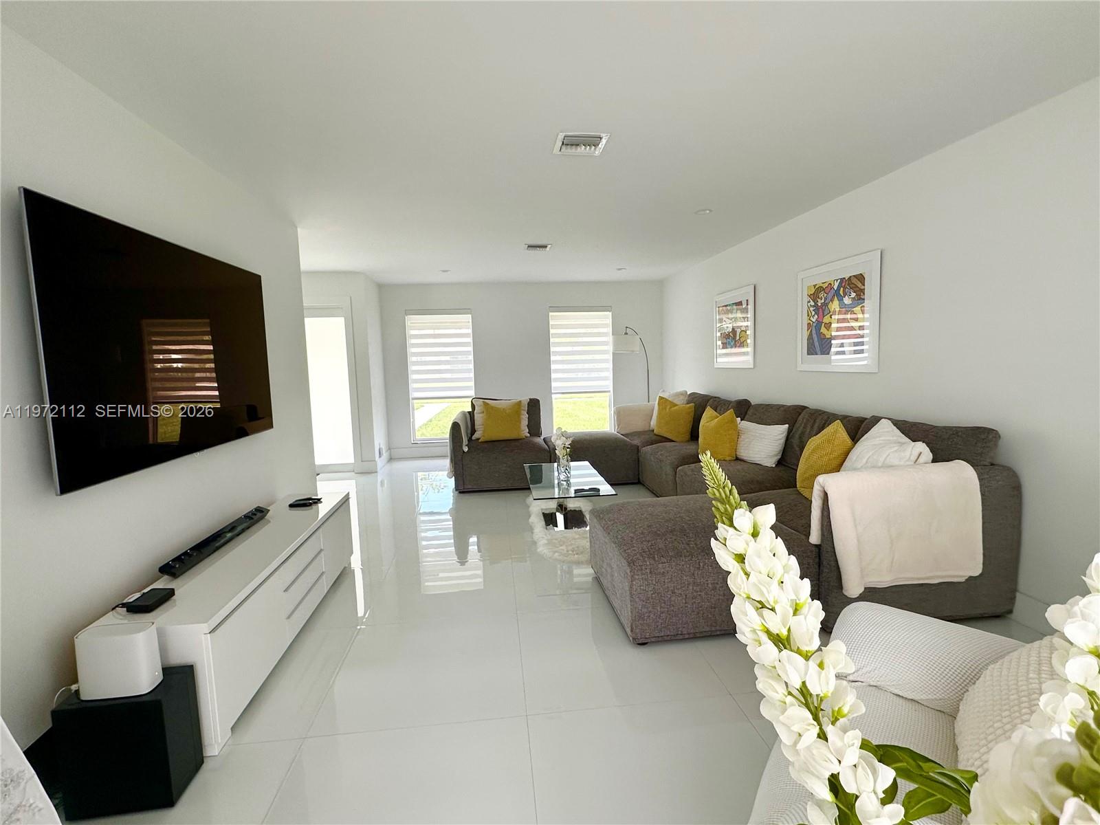 9230 Southwest 68th Street Miami, FL 33173 - Photo 6 of 29 a living room with furniture and a flat screen tv