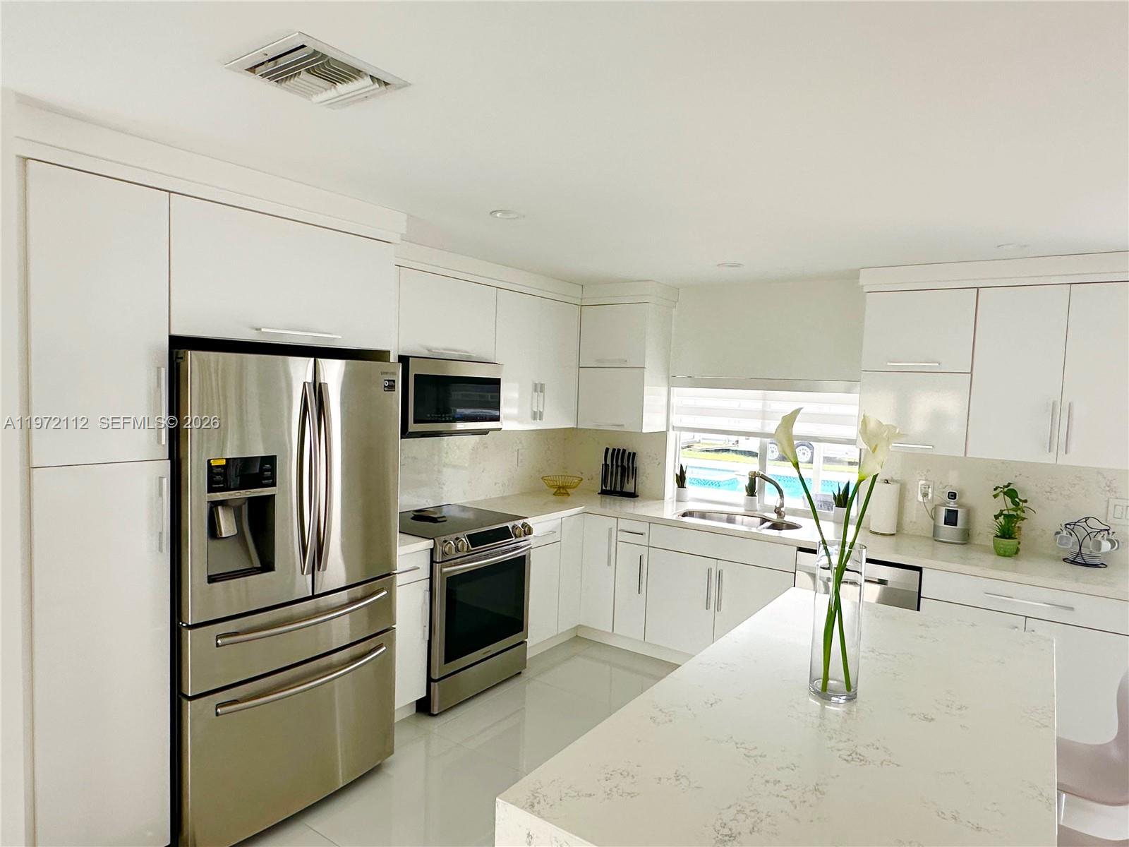 9230 Southwest 68th Street Miami, FL 33173 - Photo 7 of 29 a kitchen with stainless steel appliances granite countertop a sink a stove and a refrigerator