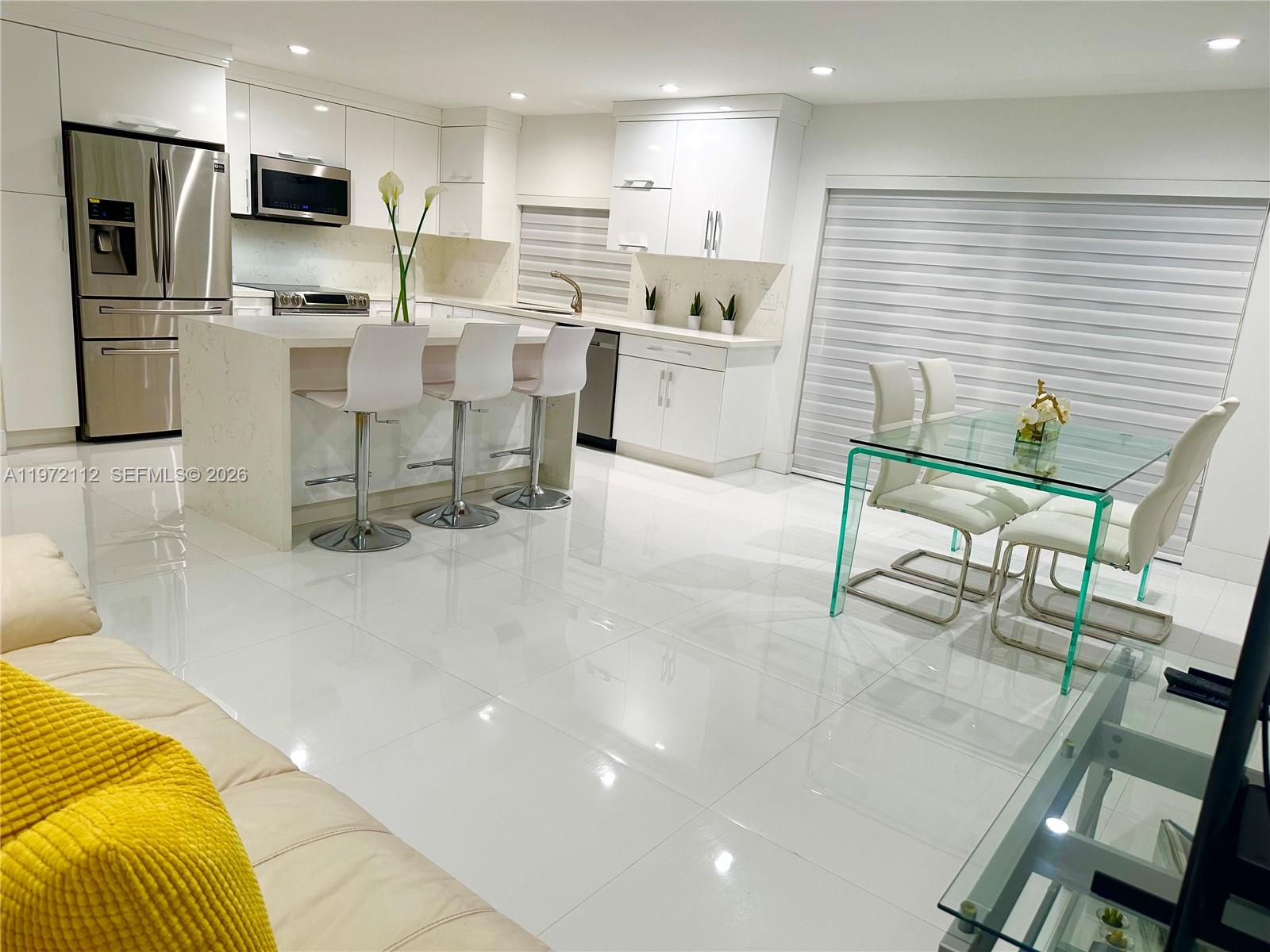 9230 Southwest 68th Street Miami, FL 33173 - Photo 9 of 29 a kitchen with stainless steel appliances kitchen island granite countertop a sink and cabinets