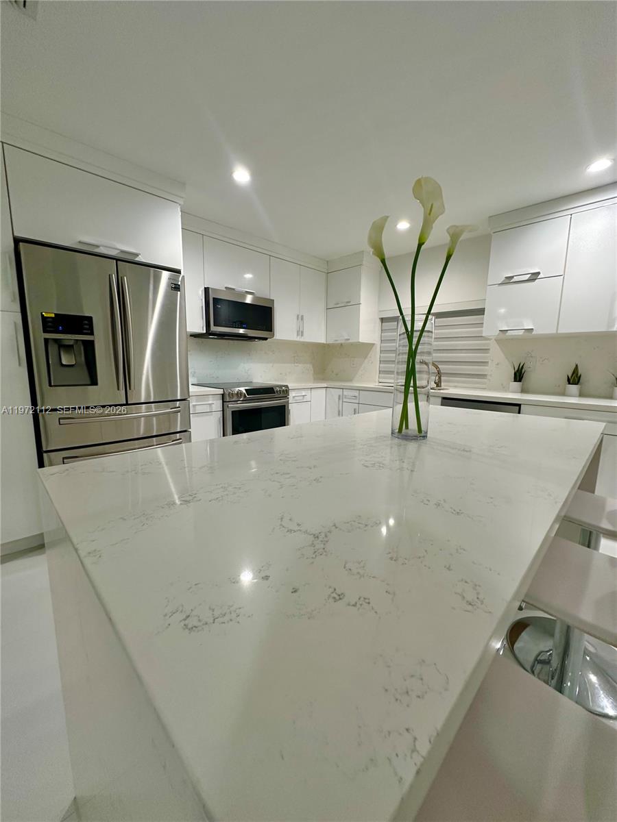 9230 Southwest 68th Street Miami, FL 33173 - Photo 10 of 29 a kitchen with stainless steel appliances a sink a stove and microwave