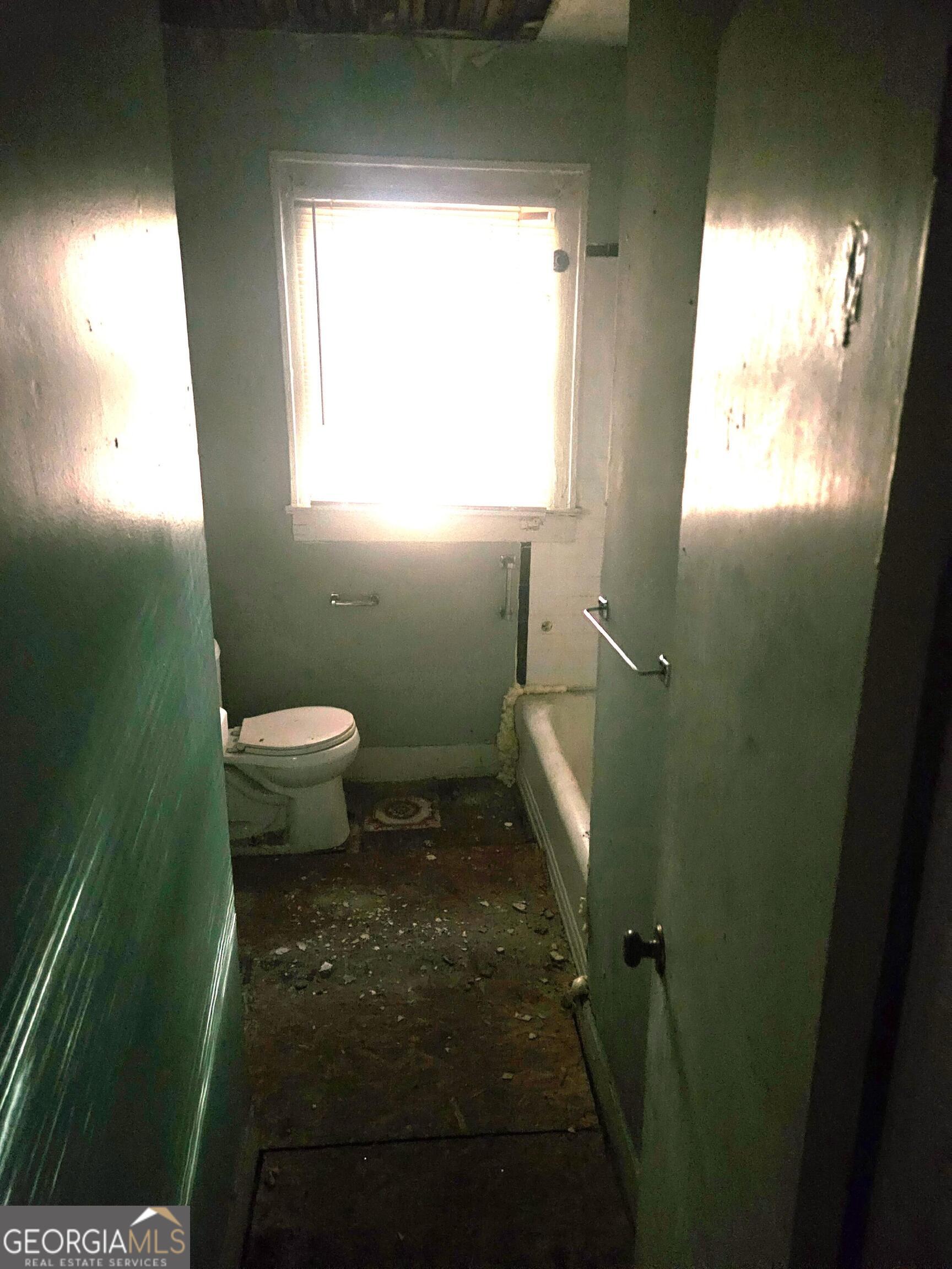 604 Hicks Street Waycross, GA 31501 - Photo 7 of 10 a bathroom with a toilet a sink and a window