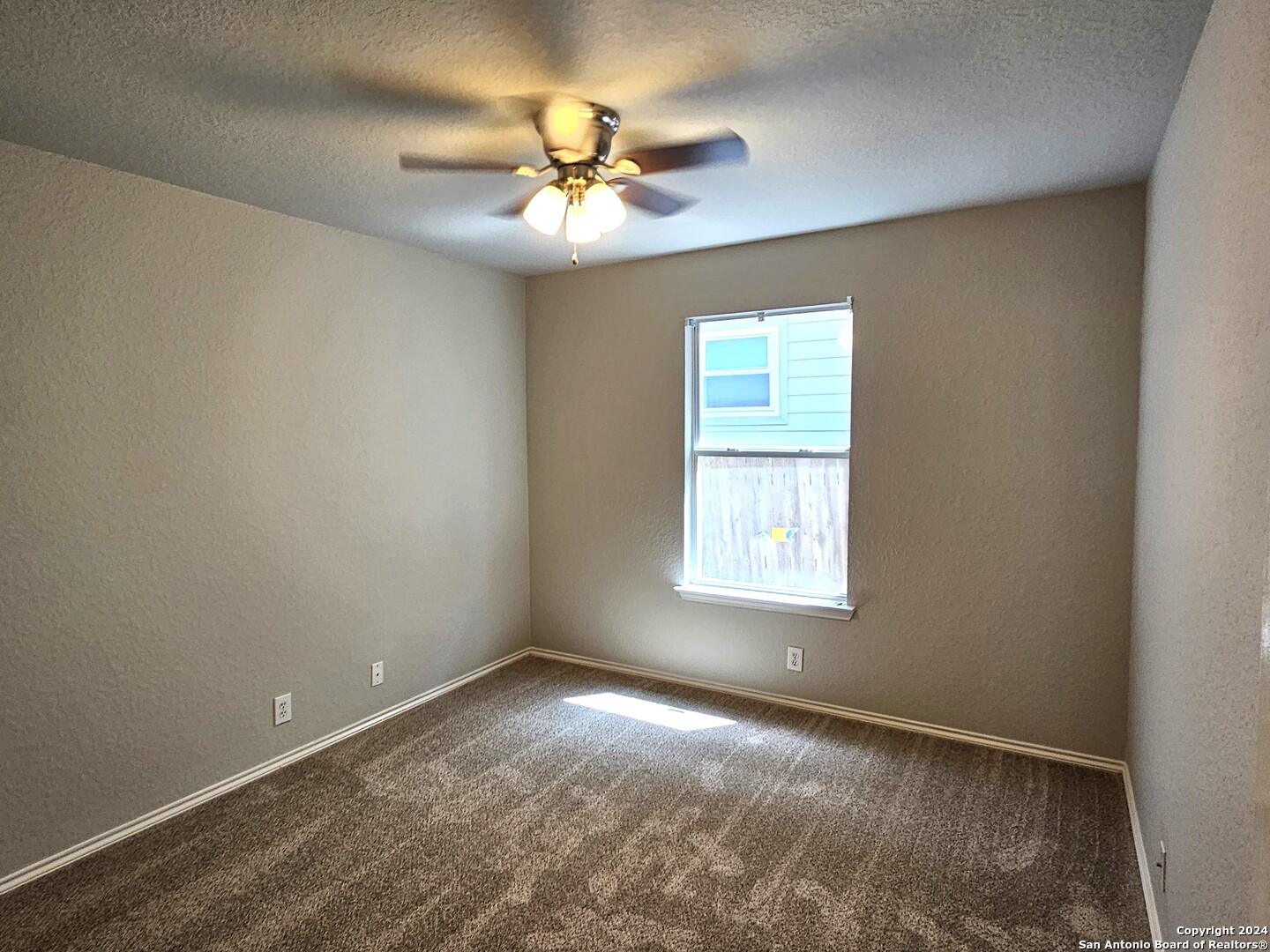 3321 Whisper Bluff Schertz, TX 78108 - Photo 12 of 17 an empty room with windows and chandelier fan