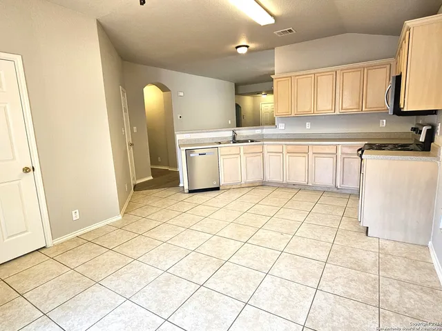 a kitchen with stainless steel appliances a stove a sink and a refrigerator