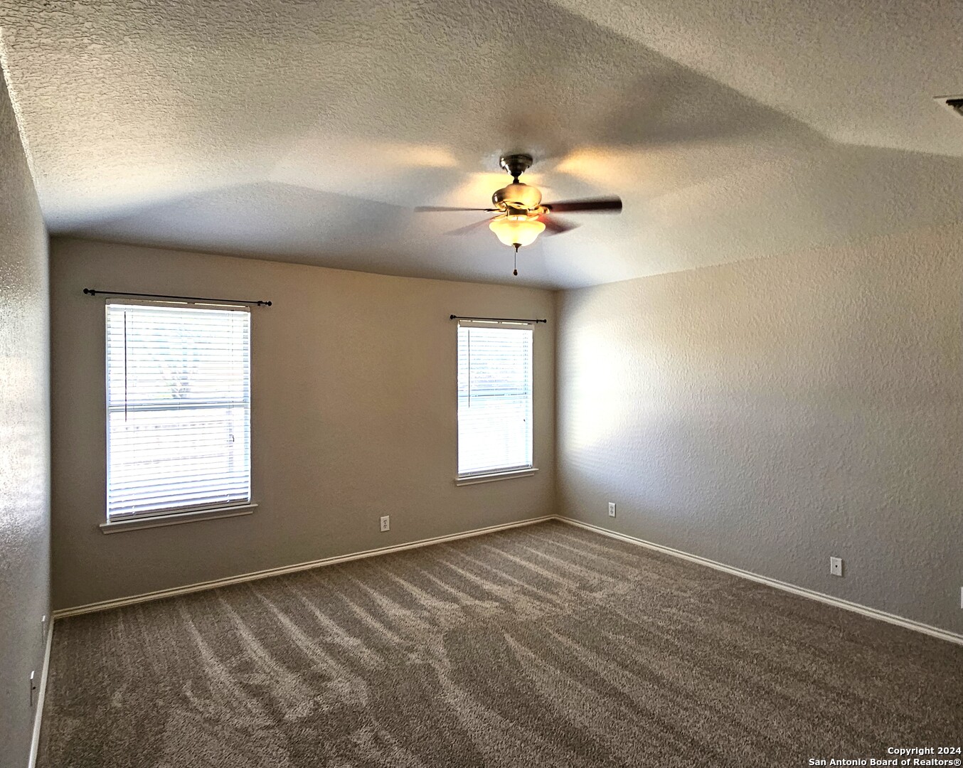 3321 Whisper Bluff Schertz, TX 78108 - Photo 9 of 17 an empty room with windows and chandelier fan