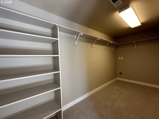 a view of walk in closet with empty racks