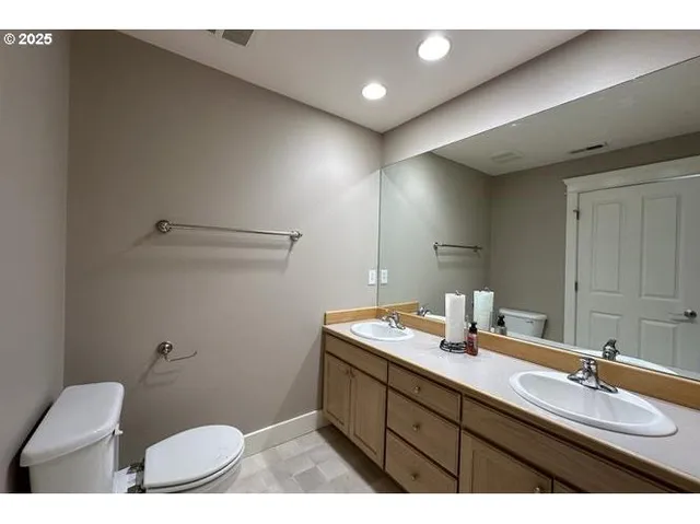 a bathroom with a sink mirror vanity and toilet